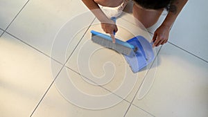 Top view of a woman, housewife or maid cleaning and sweeping floor at home in the balcony. Housekeeping concept.