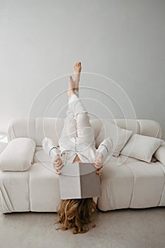 Top view of woman lying on sofa with book