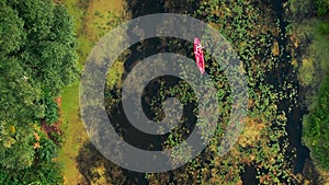 Top view of woman paddling on red kayak in river at summer. Vertical video