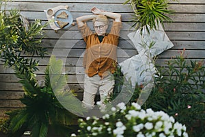 Top view of woman relaxing, lying on garden patio with closed eyes. Mother having moment to herself while her child is