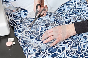 Top view of woman`s hands cutting fabric