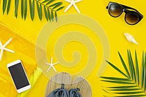 Top view woman`s things for beach, sunglasses, towel. phone and slippers. Flat lay frame with space for banner decorated