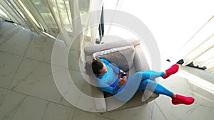 Top view. Woman sitting comfortably in a chair near a large window in a luxurious villa.