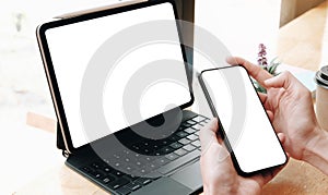 Top view Woman sitting and holding blank screen mock up mobile phone and mock up computer