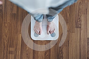 Top view, woman standing on body scale, checking body weight, dieting, lose and gain weight concept