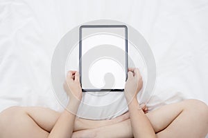 Top View of Woman Watching Her Blank Tablet with Empty Space on the Bed