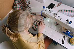 Top view of woman working with sewing machine in her workshop