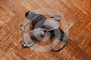 Woman bra thrown on wooden floor