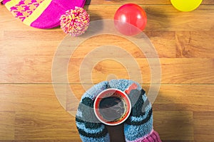 Top view women`s hands, gloves, Silk hat, colored balls and a cup of coffee on wood table.