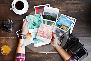 Top view of women`s hands holding printed photos