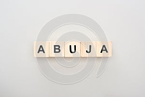 Top view of wooden blocks with Abuja lettering on grey background.