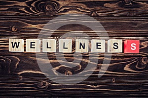 top view of wooden blocks arranged in wellness word in brown
