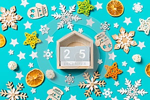 Top view of wooden calendar on blue background with New Year toys and decorations. The twenty fifth of December. Christmas time