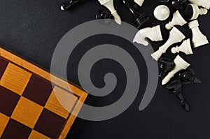 Top view of wooden chess board and pieces on the black background.Empty space