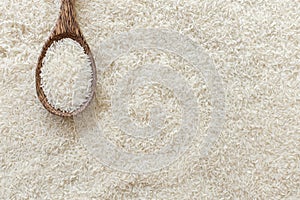 Top view of Wooden ladle on many rice texture background