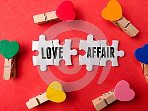 Top view wooden love clips and white puzzle with text LOVE AFFAIR