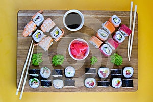 Top view of wooden platter with great set of delicious Nigiri sushi and Tempura rolls with Maki and Uramaki rolls