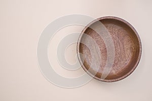 Top view of a wooden round tray on a beige background