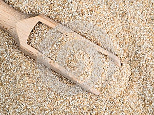 Top view of wooden scoop in rye bran