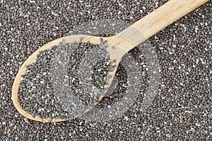 Top view of wooden spoon full of dried Chia seeds (Salvia hispanica)