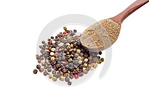 Top view of a wooden spoon full of grind black pepper and peppercorn on white background, shallow depth of field.