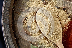 Top view of a wooden spoons full of curry on wooden barrel background, selective focus.