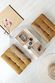 Top view on wooden table with cups between poufs in dining room photo