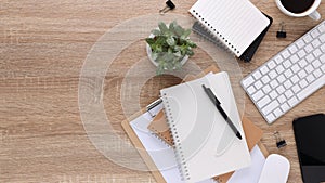 Top view wooden workspace office desk with computer and office supplies. Flat lay work table with blank notebook, keyboard, pen ,