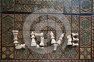 Top view of the word Love from chess pieces on an inlaid chessboard, selective focus