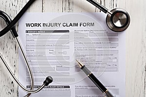 top view work injury claim form with stethoscope medical and insurance concept