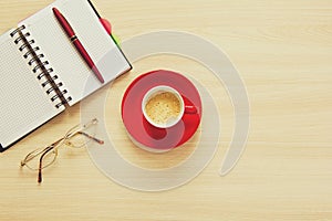 Top view on work table. Coffee cup, glasses, notes and pen