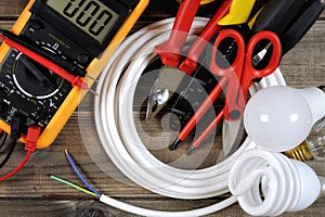 Top view of work tools and electrical system components on antique wooden background.