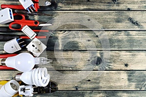 Top view of work tools and electrical system components on rustic wooden background