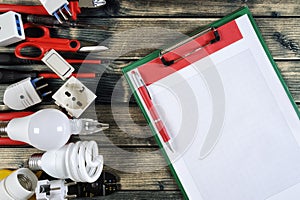 Top view of work tools and electrical system components on rustic wooden background