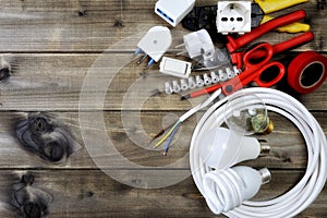 Top view of work tools and electrical system components on wooden background