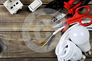 Top view of work tools and electrical system components on wooden background