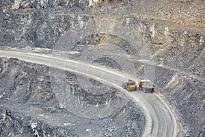 Top view of working BelAZ dump trucks in a stone and crushed stone quarry in Russia, Chelyabinsk region, Miass city