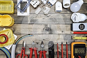 Top view of working tools and components of the residential electrical system on rustic wooden background