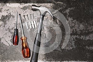 Top view working tools, hammer, screwdrivers and plastic anchors on cement background photo