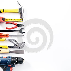 Top view of Working tools,wrench,socket wrench,hammer,screwdriver,plier,electric drill,tape measure,machinist square on white