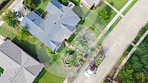 Top view working truck with a lift cutting down tree at suburban house near Dallas, Texas, USA