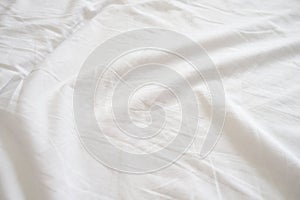 Top view of wrinkles on an untidy white bed sheet, linen in a bedroom after a long night sleep and waking up in the