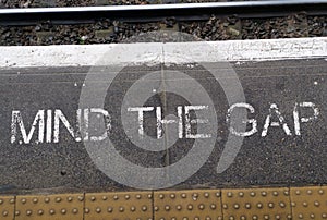 Top view of the "mind the gap" sign on the ground at the London railway station