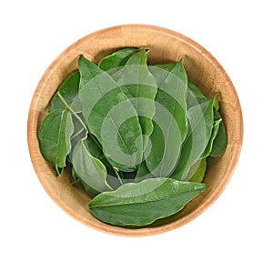 Top view of Yanang leaf in wooder bowl on white background