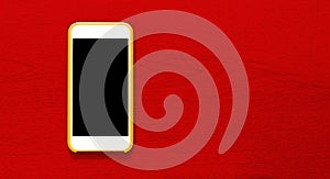 Top view of yellow cell phone with isolated black screen that contrasts with red background with wood texture and ample copytext