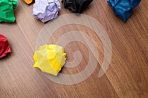Top view of yellow crumpled paper ball on dark brown wood table