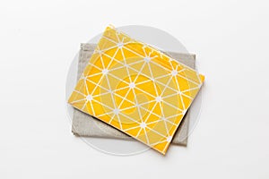 top view with yellow empty kitchen napkin isolated on table background. Folded cloth for mockup with copy space, Flat