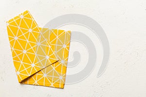 top view with yellow empty kitchen napkin isolated on table background. Folded cloth for mockup with copy space, Flat