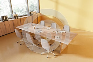 Top view of yellow meeting room interior with table, sideboard and window