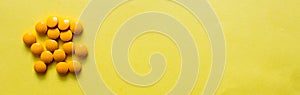 top view  yellow pillows of dietary supplements on yellow background. copy space. Concept of healthy life, vitamin. Banner